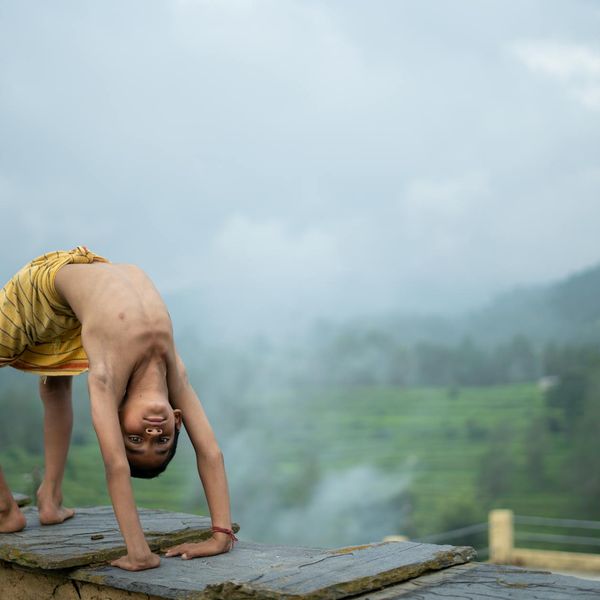 Person meditating outdoors with a serene landscape in the background.